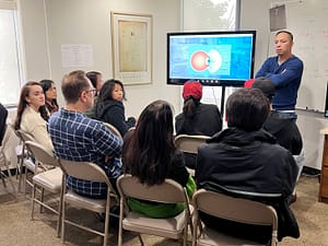 Group of doctors listening to a doctor give a presentation about contact lenses.